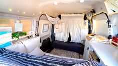 the interior of a camper van with bed and desk