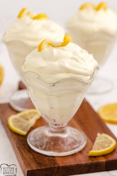 lemon meringue in a glass dish on a cutting board with sliced lemons