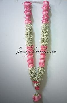 two pink and white flowers are attached to a necklace