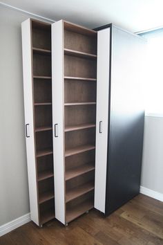 an empty room with two tall bookshelves next to each other on the floor