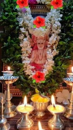 the altar is decorated with flowers, candles and an image of lord ganesha