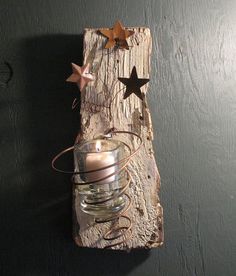 a candle holder made out of an old piece of wood with stars on the top