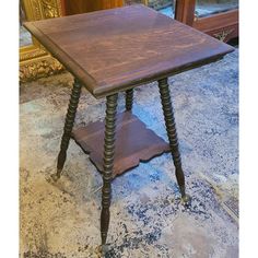 an old wooden table sitting on top of a carpeted floor next to a mirror