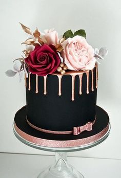 a black and pink cake with roses on top