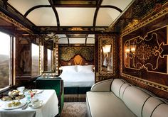 the interior of a train car with two beds and a table in front of it