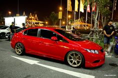 a red car parked on the street at night