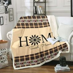 a living room with a couch, chair and table covered in a blanket that says home sweet home