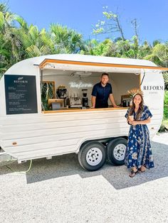 a man and woman standing in front of a food truck