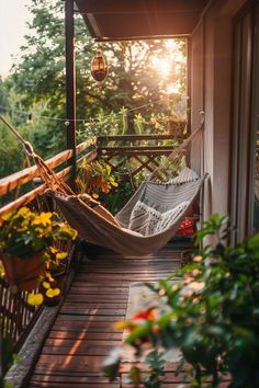 a hammock hanging from the side of a porch next to flowers and plants