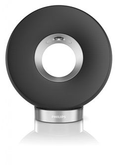 a black and silver speaker on top of a white surface with a circular hole in the center