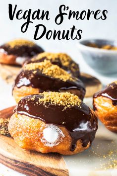 chocolate covered doughnuts with sprinkles on wooden cutting board next to bowl of powdered sugar