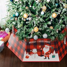 a christmas tree in a box with ornaments on it and a santa clause card underneath