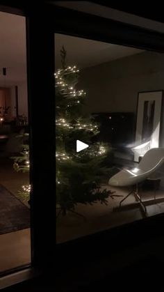 a living room filled with furniture next to a window covered in christmas tree lights at night