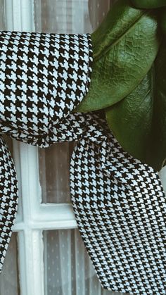 a black and white checkered ribbon hanging on the side of a window