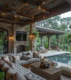 an outdoor living area with couches, tables and a pool in the back ground