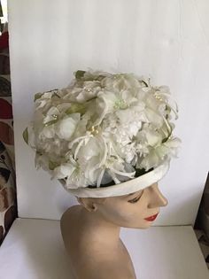 "Vintage 1960's hat. White floral with Green leaves bucket style hat. The label is *SEARS Fashion Millinery*. Sears Roebuck and Co. USA. *MORE INFORMATION BELOW* CONDITION: No issues noted. MEASURES: Inside circumference~21 1/2\" Height~5\" Front to back~8\" Left to right~7\" *WE APOLOGIZE~BUT WE NO LONGER SHIP TO GERMANY, ITALY OR SPAIN. IF ORDERS COME IN FROM GERMANY, ITALY OR SPAIN, WE WILL HAVE TO CANCEL THEM AND REFUND YOUR MONEY. SORRY FOR THIS INCONVENIENCE*" White Vintage Cloche Fascinator, Vintage White Cloche Fascinator, Vintage White Bonnet For Wedding, Vintage White Adjustable Bonnet, Vintage White Headpiece For Kentucky Derby, White Fitted Vintage Bonnet, White Adjustable Vintage Bonnet, Vintage White Wedding Bonnet, Retro Wide Brim White Hat