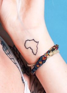 a woman's arm with a tattoo on her left wrist and the outline of africa