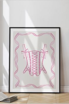 a pink and white drawing in a frame on the floor