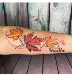 a woman's arm with leaves and the words breathe on it