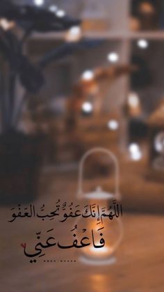 an arabic text on a blurry background with a lantern in the foreground and other items behind it