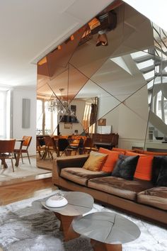 a living room filled with lots of furniture and mirrors over the top of it's walls