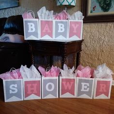 baby shower gift bags sitting on top of a wooden table