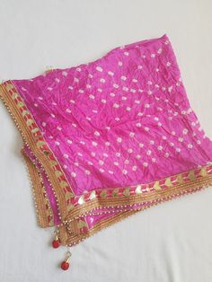 Ethnic Beautiful Bandhej Rajasthani silk Dupatta with heavy gotawork , latkans and pearls to be paired with ethnic Kurtas or white kurtas which gives a unique look which is a must buy.These dupattas have all four side pearl border for a attractive look. Dupatta length 2.25 metre Kundan Choli With Gota Work For Eid, Gold Saree With Gota Work For Puja, Gold Katan Silk Traditional Wear With Gota Work, Katan Silk Traditional Wear With Gota Work For Eid, Diwali Chanderi Choli With Gota Work, Pink Chandbali Shaped Dupatta In Chinon, Eid Banarasi Silk Choli With Gota Work, Gold Traditional Wear For Navratri Festival, Semi-stitched Traditional Wear With Pallu For Festivals