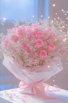 pink roses and baby's breath in a bouquet on top of a white box