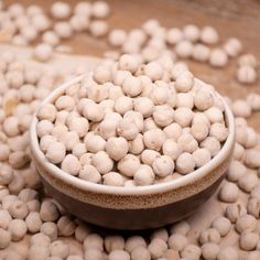 a bowl filled with white balls sitting on top of a wooden table