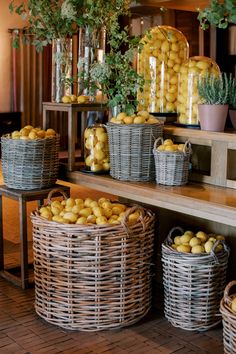 baskets filled with lemons sitting on top of a wooden shelf