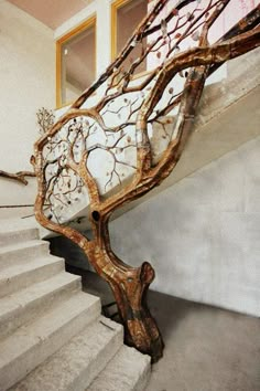 a staircase with tree branches on it next to a window