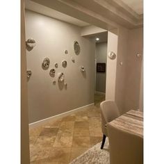 a dining room table and chairs in front of a wall with plates on it