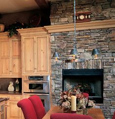 a kitchen with wooden cabinets and red chairs