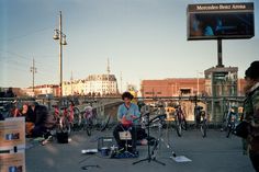 a group of people standing around with musical instruments in front of them on the street