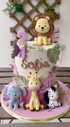 a cake decorated with animals and the word sosia on top is sitting on a table