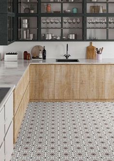 a kitchen with black and white tile flooring next to a counter top oven in the middle