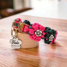 a wooden holder with two bracelets and a name tag on it sitting on a table