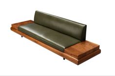 a green leather couch sitting on top of a wooden table