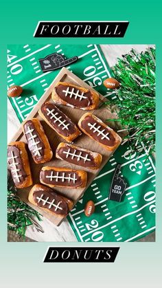 some hot dogs with football on them are sitting on a table next to green napkins