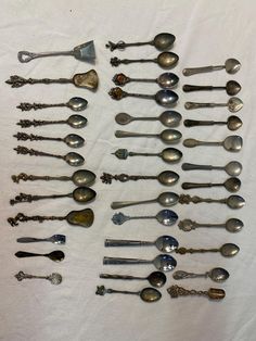 an assortment of spoons are displayed on a white tablecloth