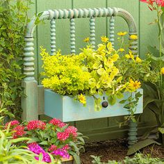 a garden bench with flowers growing in the planter and on it's side