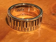 a ring with the number 925 on it sitting on top of a wooden table