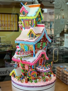 there is a large cake made to look like a gingerbread house with candy on top