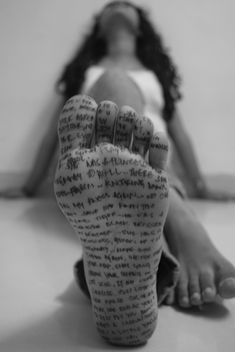 a woman laying on the floor with her foot up in front of her face and hand