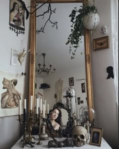 there is a mirror and some candles on the table in front of it with a woman's face