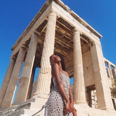 a woman standing in front of an ancient building