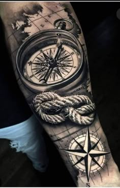 a man's arm with a compass and rope on it