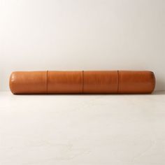 a large roll of brown leather sitting on top of a white counter next to a wall