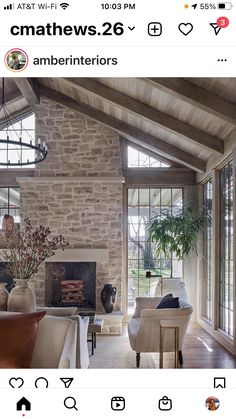 a living room filled with furniture and a fire place in front of a stone wall