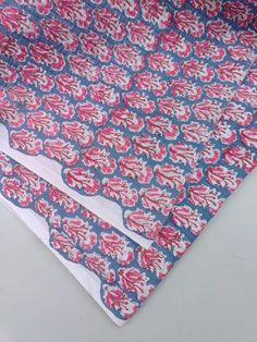 two pieces of cloth with red and blue designs on them, sitting next to each other